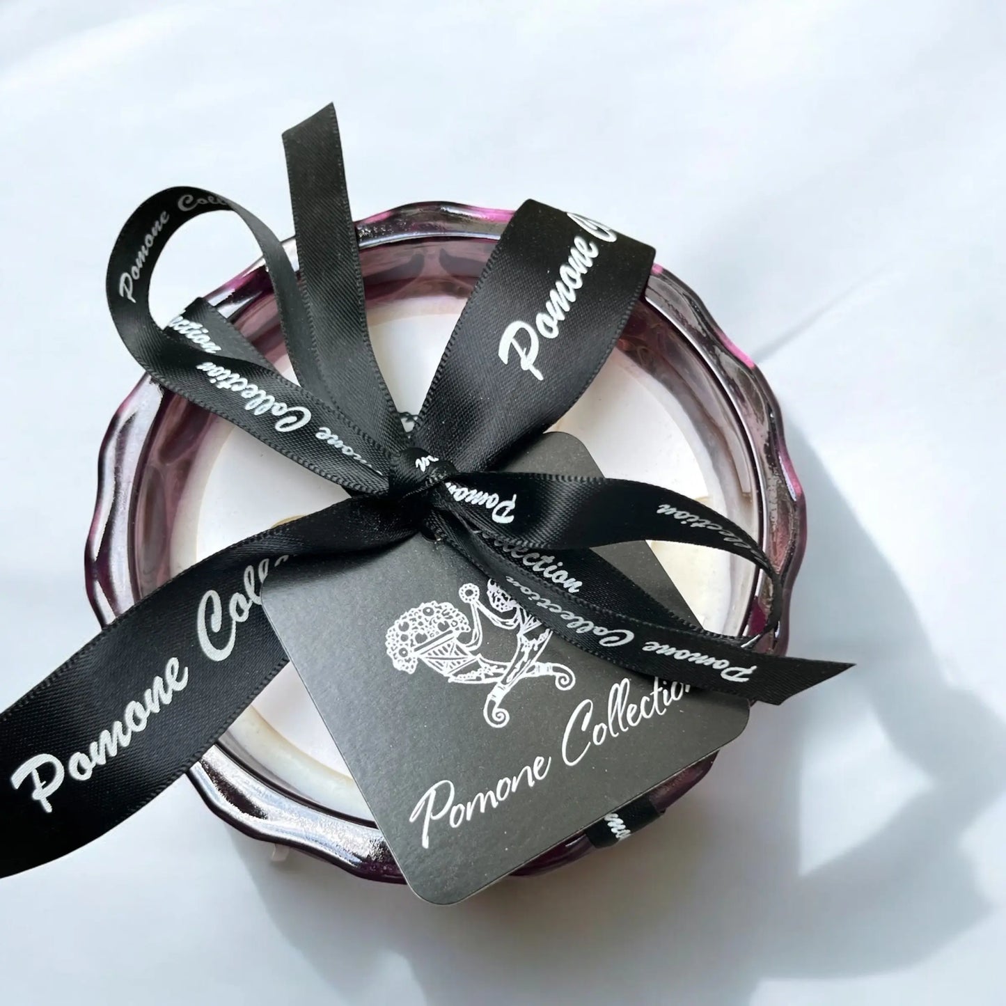 Bougie couleur aubergine, vue de haut avec ruban et étiquette