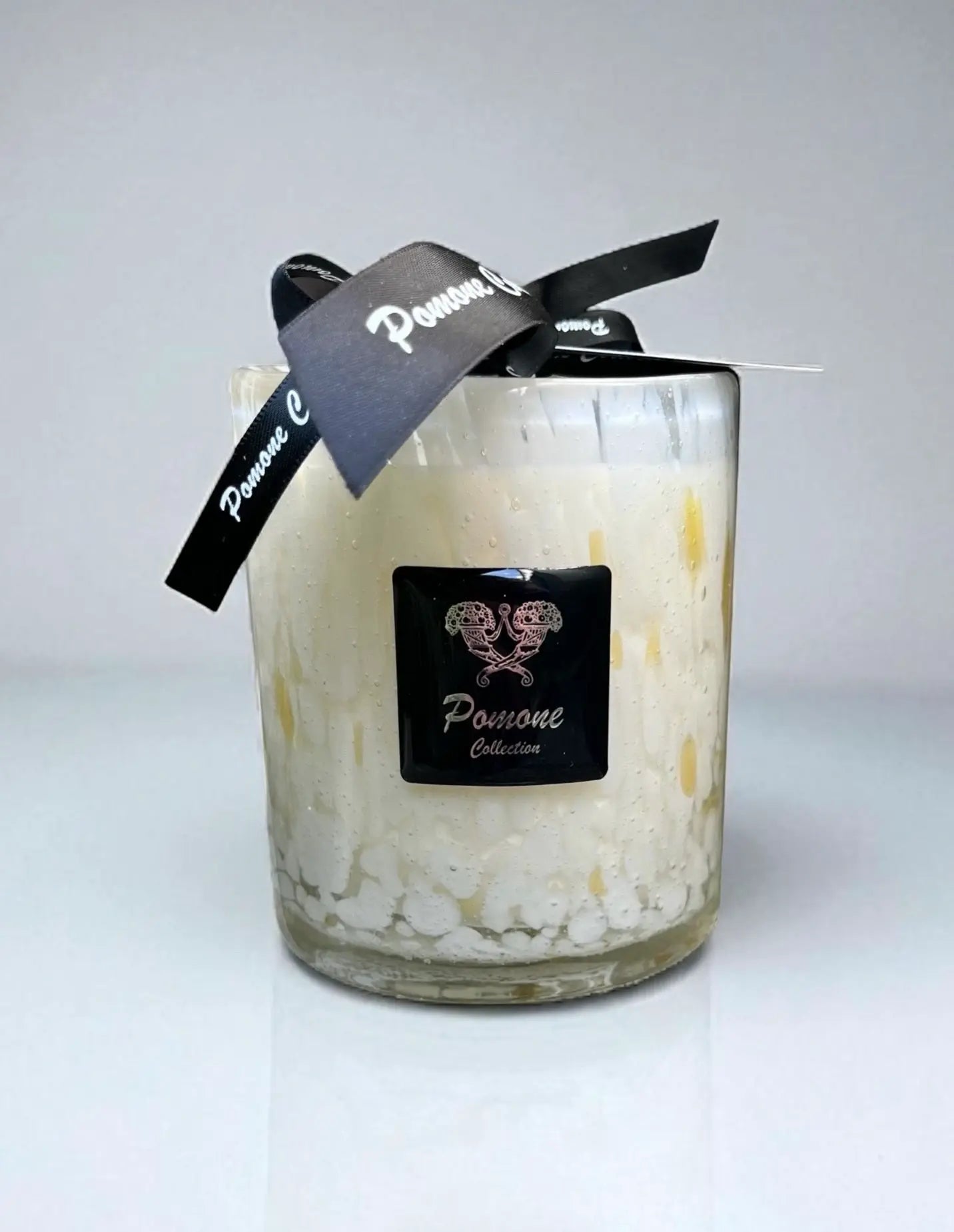 Bougie blanc cassé et jaune, vue de face sur fond blanc