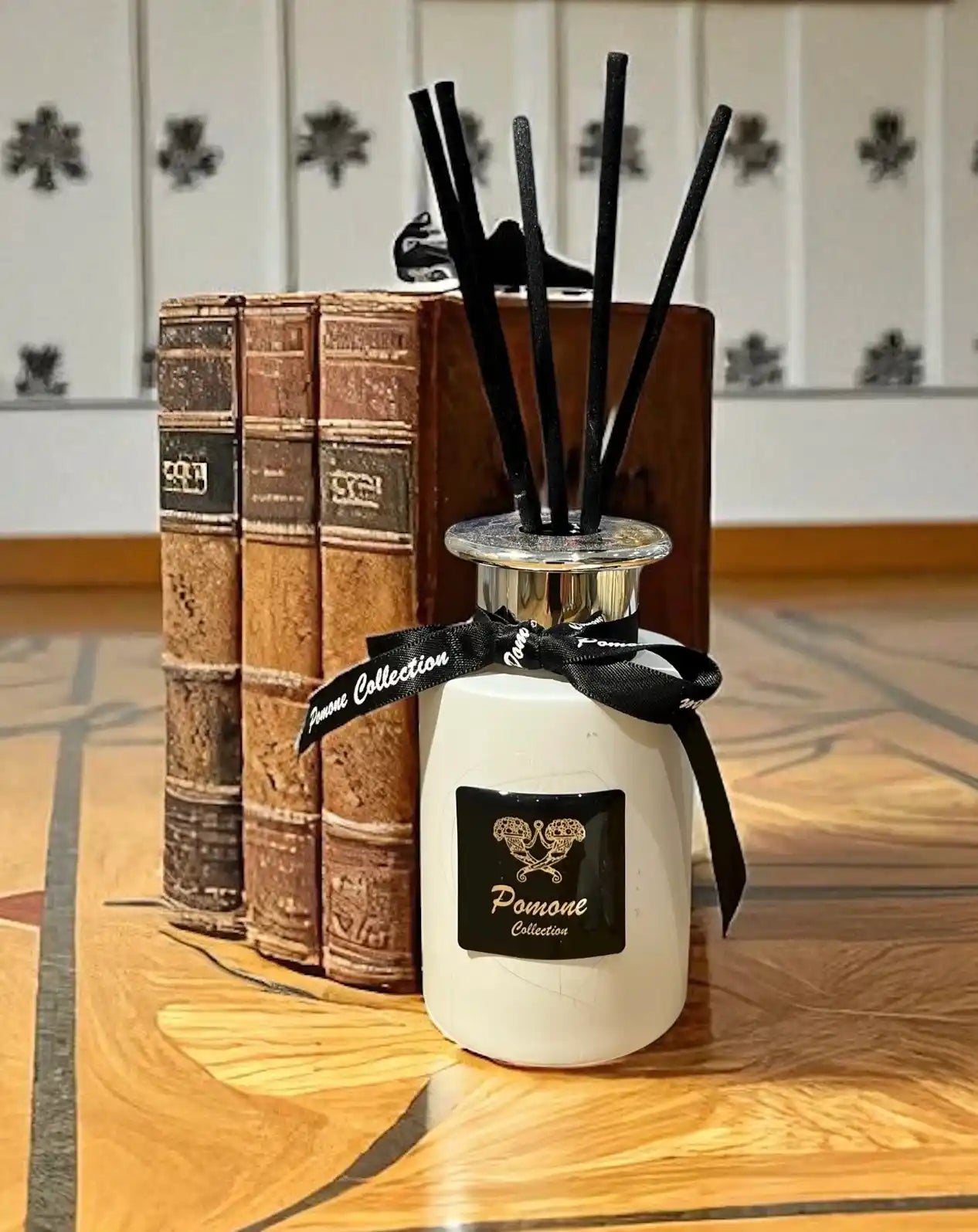 Diffuseur de parfum blanc, vue de face aux côtés de livres anciens