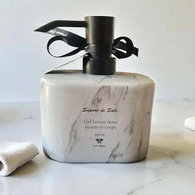 Bouteille de savon liquide couleur marbré blanc, vue de derrière, posée sur du marbre blanc