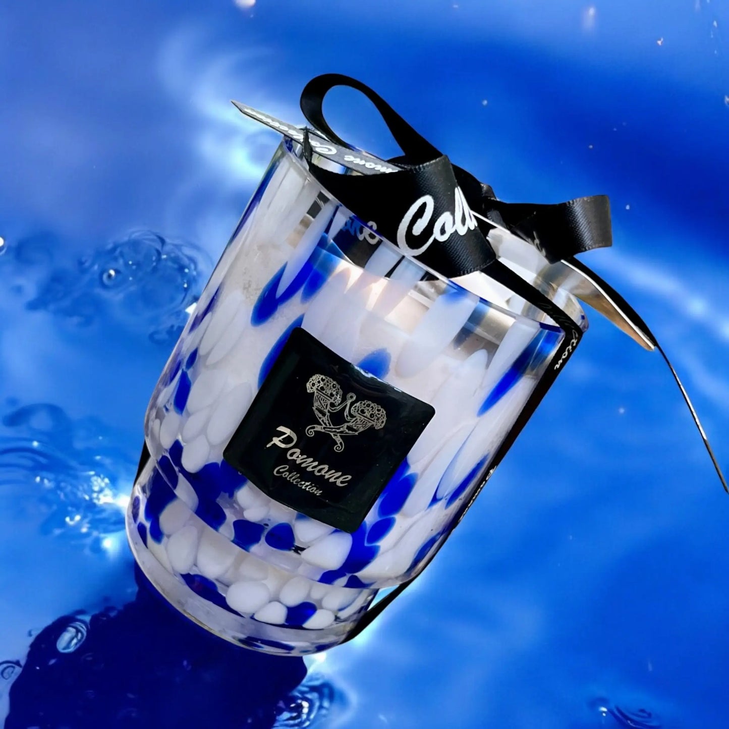 Bougie bleue et blanche, vue de face sur fond aquatique
