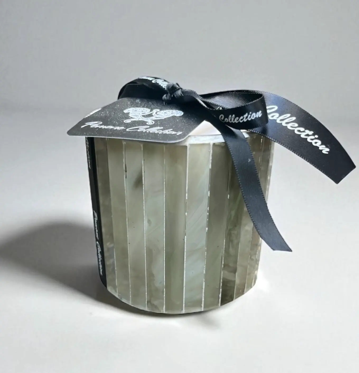 Bougie verte pâle avec étiquette et ruban, vue de face
