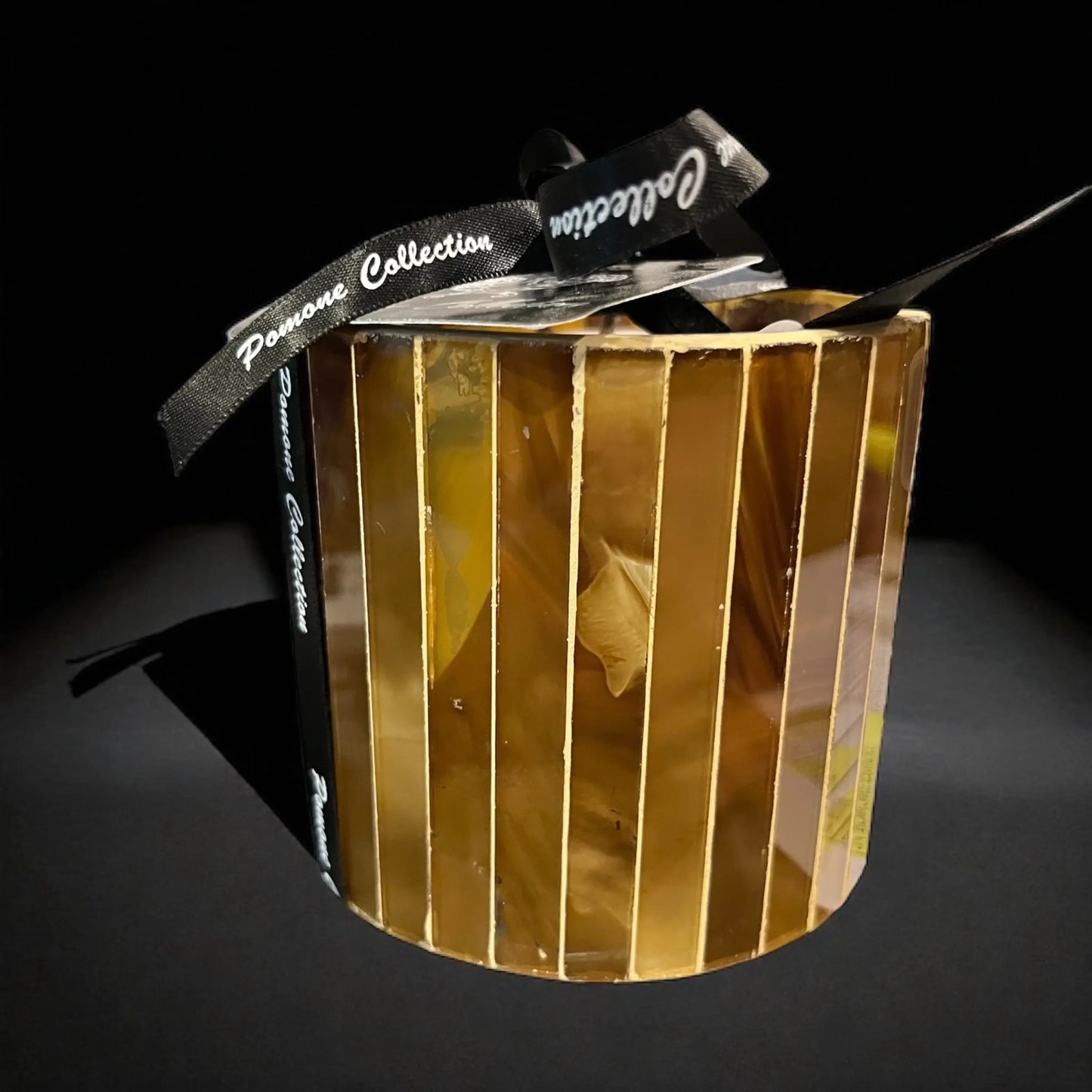 Bougie couleur cognac, ambre, sur fond noir

