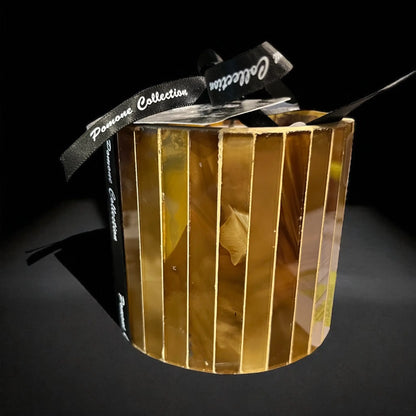 Bougie couleur cognac, ambre, sur fond noir
