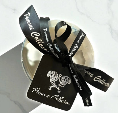 Bougie blanche nacré rose beige, vue de face posée sur du sable