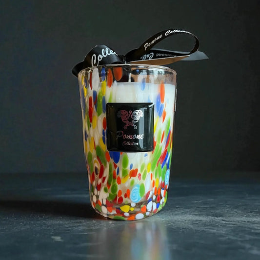 Bougie blanche et multicolore, vue de face avec ruban et étiquette sur fond noir