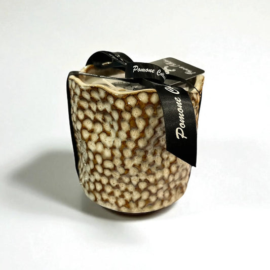 Bougie en céramique beige et blanc cassé, vue de face sur fond blanc