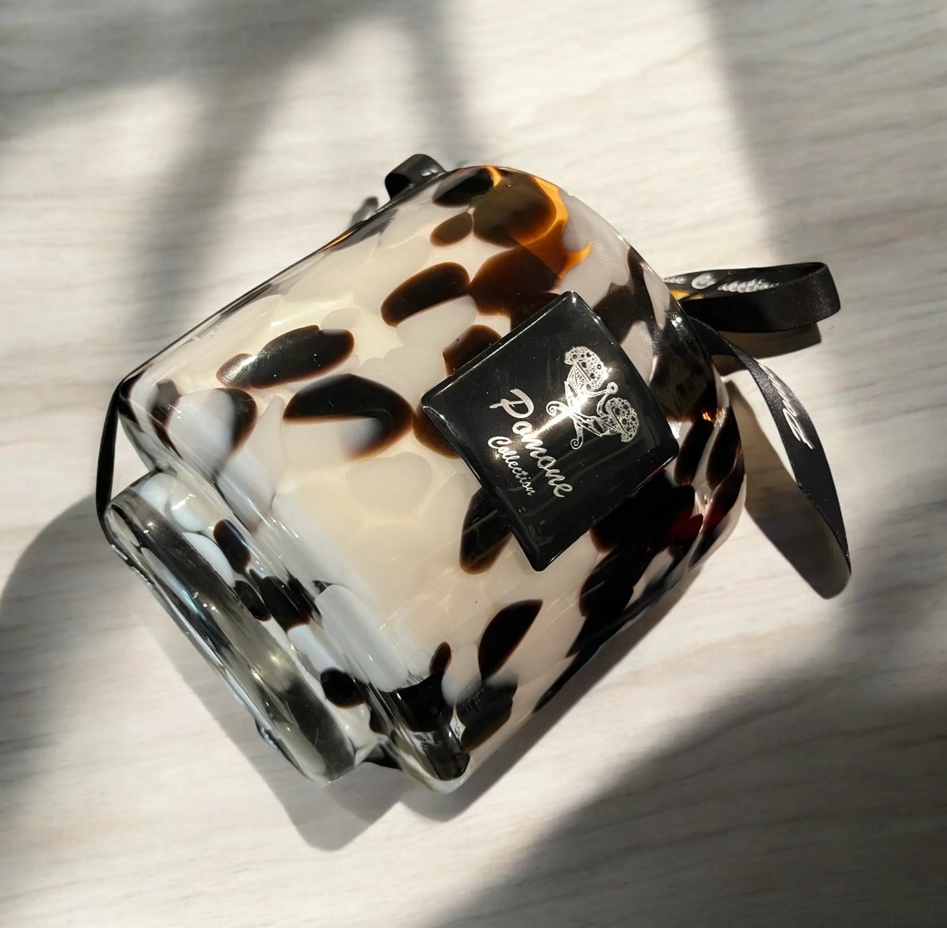 Bougie noire, brune et blanche sur meuble beige