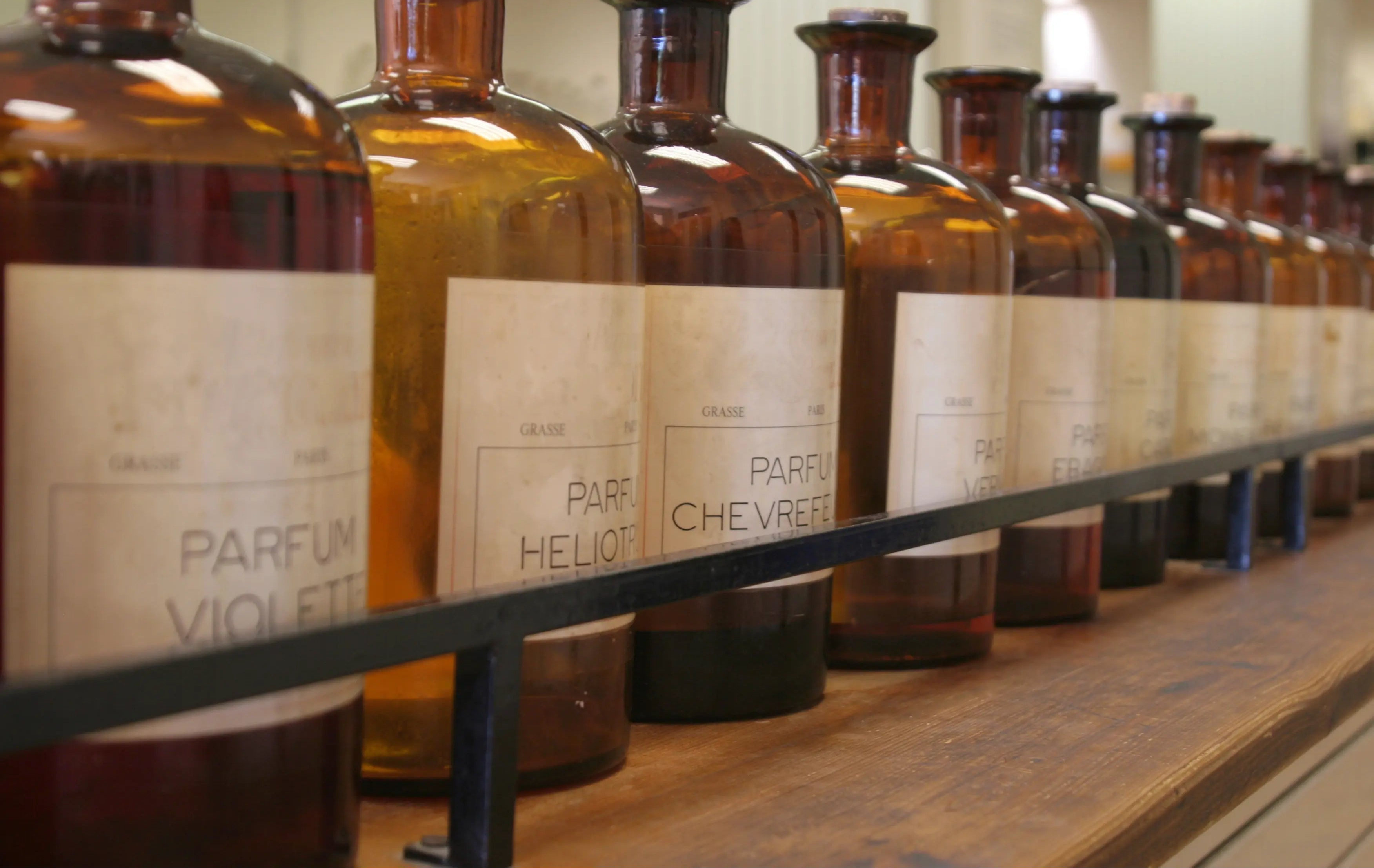 Contenants de parfum avec étiquette et nom sur étagère en bois