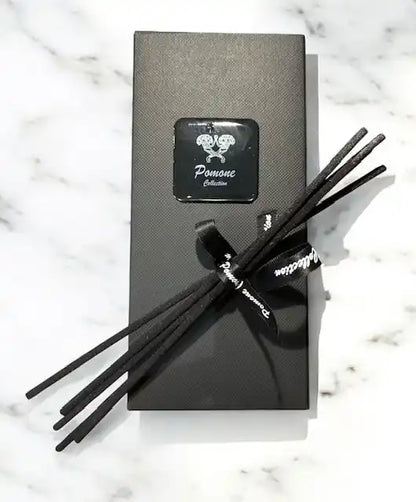 Emballage de diffuseur noir avec battons diffuseurs, vue de face sur marbre blanc