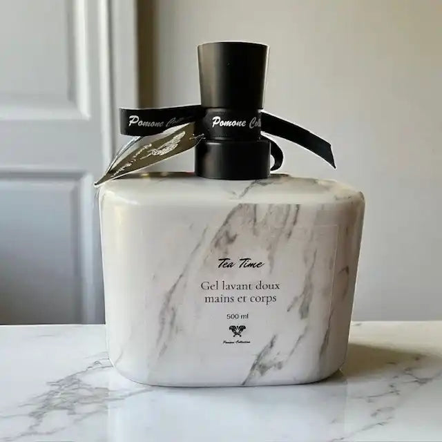 Bouteille de savon liquide couleur marbré blanc, vue de derrière, posée sur du marbre blanc